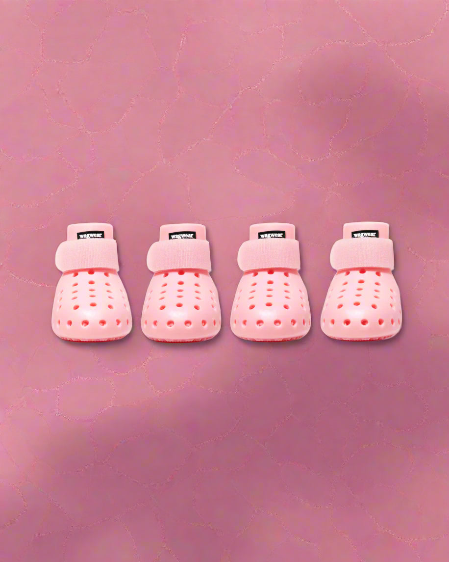 a pair of light pink dog booties that look like Crocs